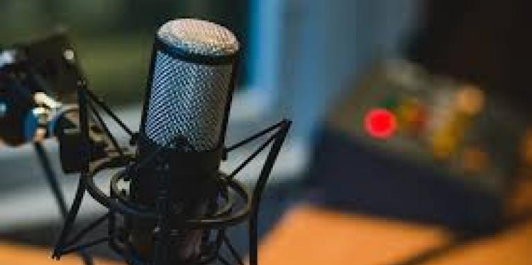 L'image montre un microphone de podcast dans un studio d'enregistrement.