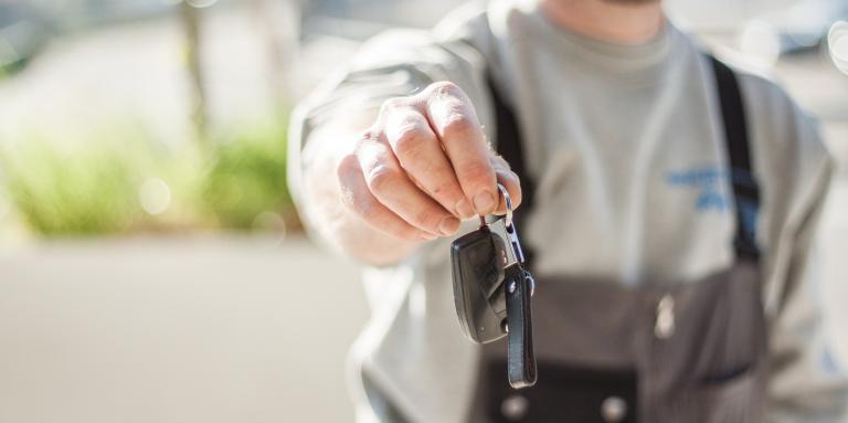 Photo of person holding out car keys