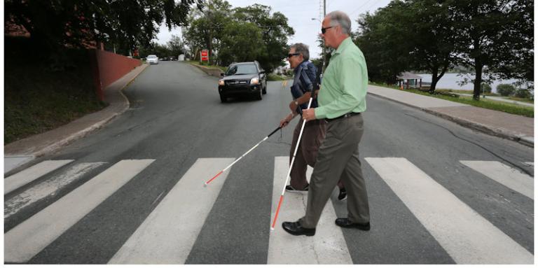 Hommes munis d'une canne blanche traversant un passage pour piétons.