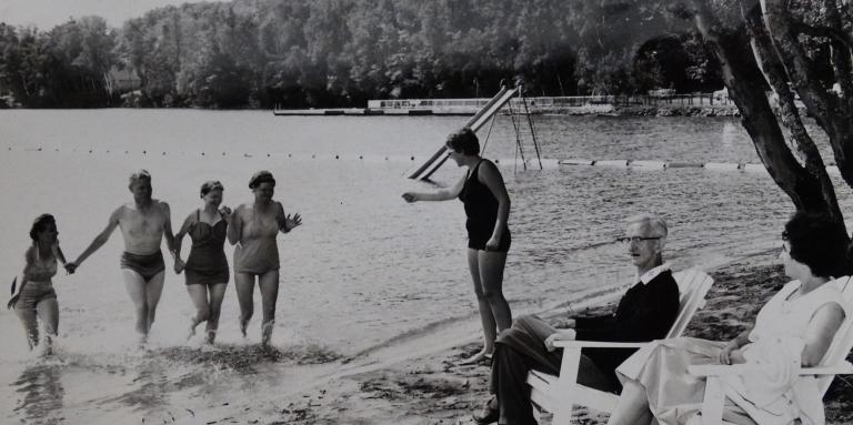 An old black and white photograph of people at CNIB Lake Joe running into the lake.
