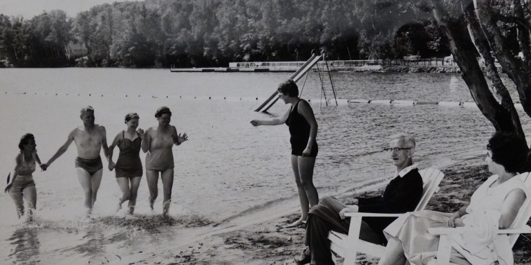 Ancienne photo en noir et blanc de campeurs sur les rives et la plage du lac en 1961