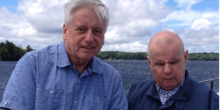 Rob Froom (à gauche) debout au bord du lac Joe avec son frère David. Rob tient la main de son frère.