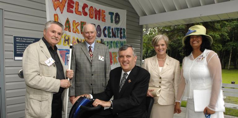 David Onley se joint à l'ancien président d'INCA, Jim Sanders, à l'ancien président du conseil d'administration d'INCA, Al Jameson, et à d'autres membres du personnel d'INCA lors d'un événement au camp Lake Joe à Muskoka, en Ontario. 