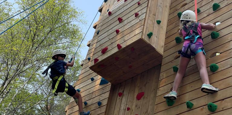 "Deux enfants escaladent une piste rocheuse."