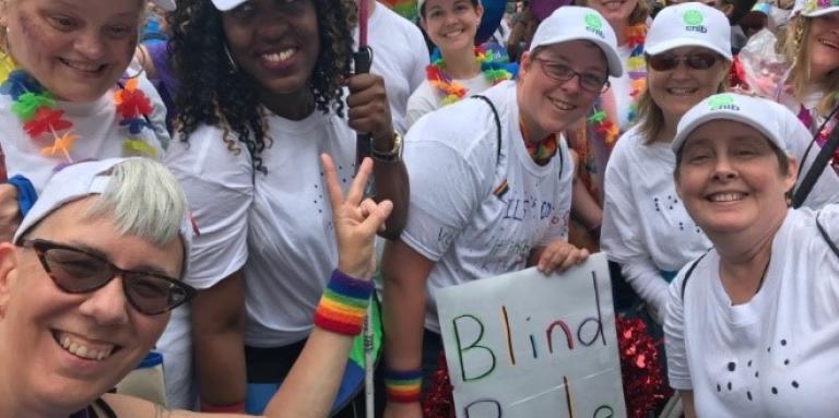 Des participants, des employés et des bénévoles d'INCA arborant des tee-shirts blancs, des casquettes de baseball et des sourires lors du défilé de la Fierté de Toronto