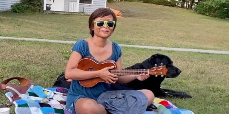  Vivian playing her ukelele on the lawn at CNIB Lake Joe.