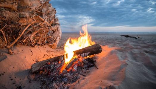 A campfire on a sandy beach. 