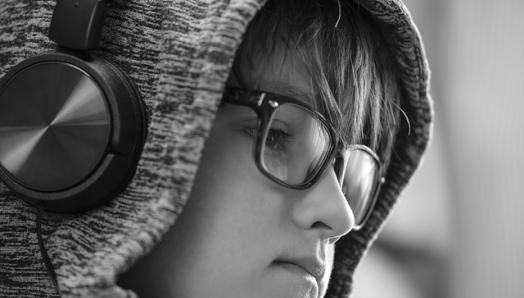 A black & white photo of a child wearing headphones.