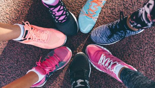 Six colourful running shoes stacked side-by-side in a circle.