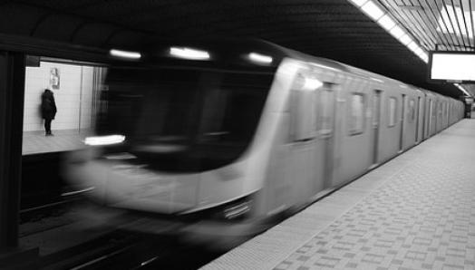 A blurry subway car breezes into a station.