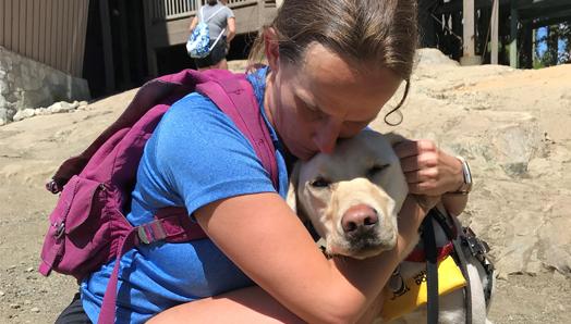 Une femme qui serre un chien-guide.