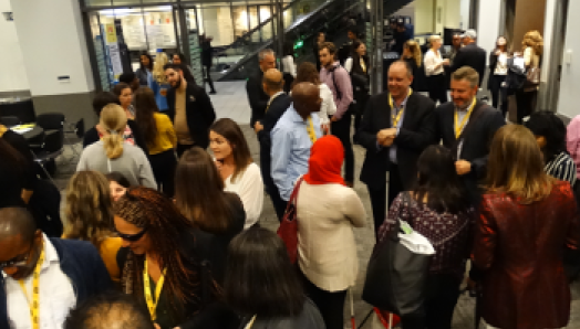 Une salle remplie de personnes se tenant en petits groupes, discutant et tissant des liens au Congrès Points de connexion de Toronto.
