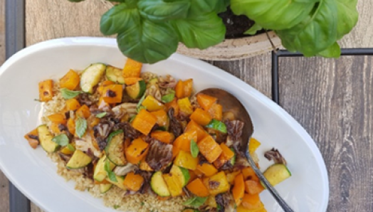 Vegetable platter filled with bell peppers, asparagus and other vegetables on top of quinoa