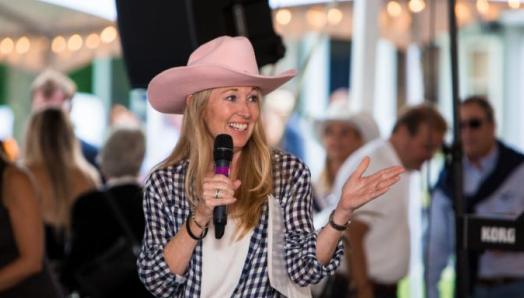 Nancy Simonot, coiffée d’un chapeau de cowgirl rose et parlant dans un microphone à l’occasion de l’événement d’INCA à Muskoka: Taste of Country.