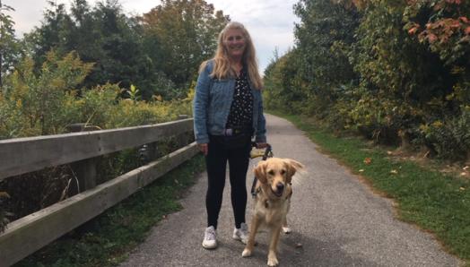 Photo de Lindsay et Charlie marchant le long d'un sentier dans un parc par une journée ensoleillée, souriant pour la photo.