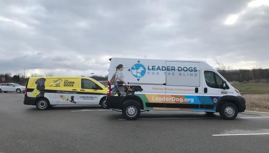 A CNIB Guide Dogs branded van (left) parked next to a Leader Dogs for the Blind van (right).