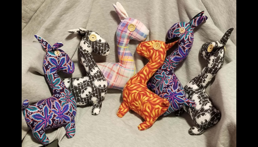 Six colourful stuffed animal Llamas, created by Jaclyn. The llamas have tactile elements like button eyes.