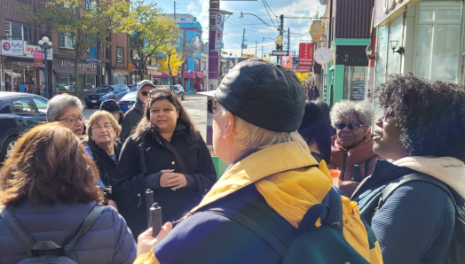 A group of CNIB participants standing outside the Udupi Palace restaurant in Toronto